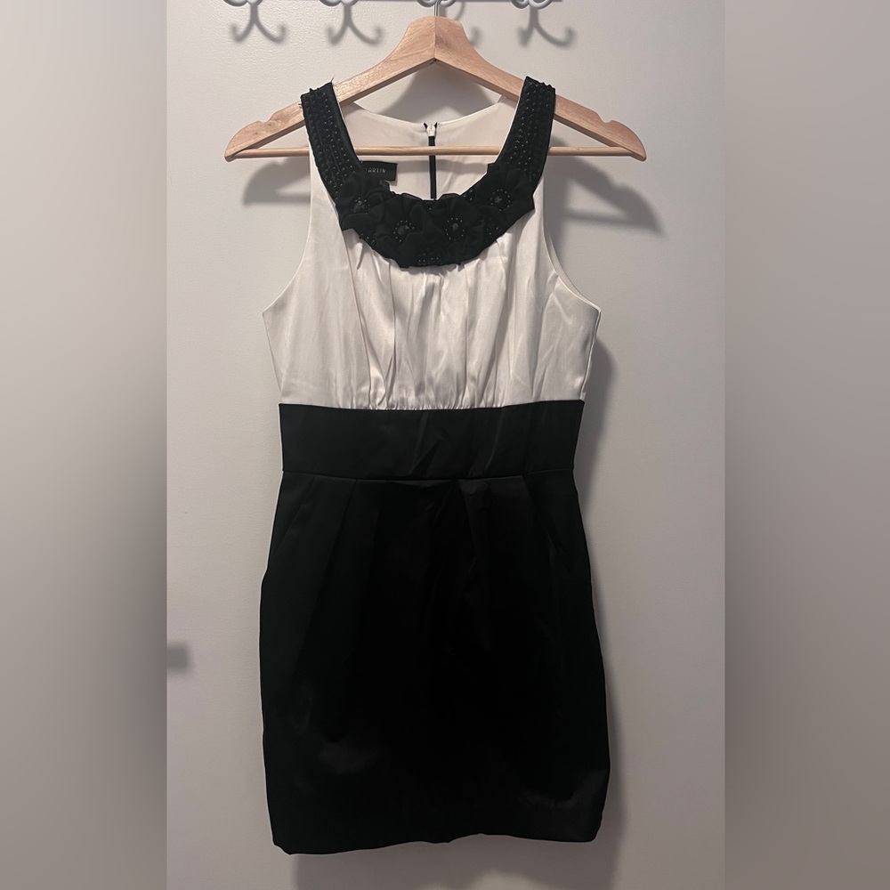Black and white dress with floral neckline and hidden pockets. Satin fabric